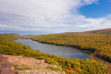 Rengarenk sonbahar ormanlarında ve yuvarlanan tepelerde yuva yapmış dingin göl..