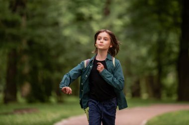 Bir çocuk saçlarında rüzgarla koşuyor..