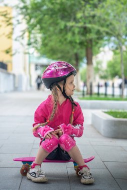 Parkta pembe kaykaylı küçük bir kız..