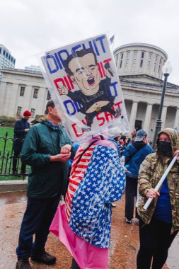 Ohio Eyalet Binası 'nın önünde suratsız kalabalık protesto işaretleriyle duruyor.