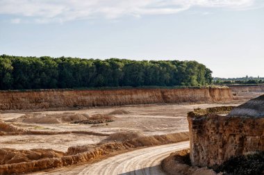Gün batımında terk edilmiş, kirli yolları olan bir açık maden ocağı. .