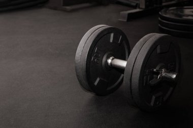 Yoğun egzersizden sonra spor salonunda dinlenen siyah dambıl.