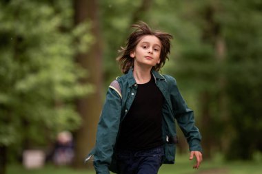 Bir çocuk saçlarında rüzgarla koşuyor..