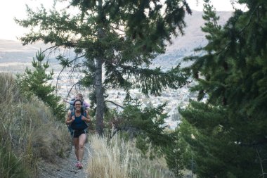 Annesi kasabanın dışında bir patikada yürür. Bebeğini sırtında taşır.