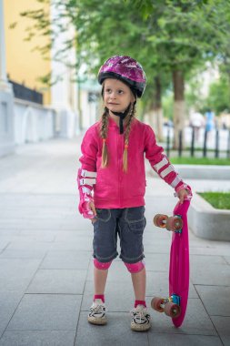 Parkta pembe kaykaylı küçük bir kız..