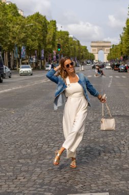 Paris 'te Champs-lyses' de poz veren kot ceketli mutlu kadın.