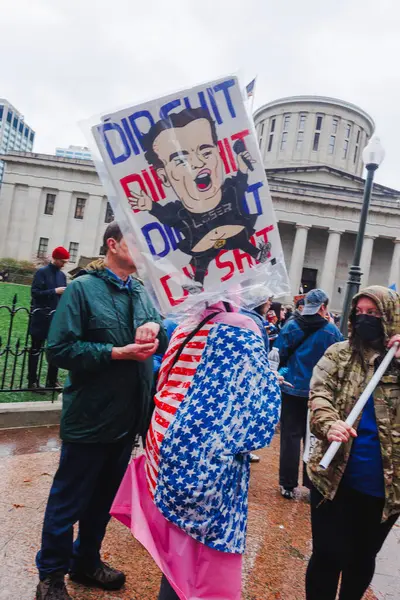 Ohio Eyalet Binası 'nın önünde suratsız kalabalık protesto işaretleriyle duruyor.