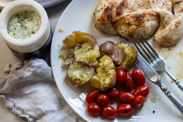 Kızarmış patatese sarımsaklı sos serpilmiş.