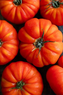 Koyu kırmızı-turuncu renkli aile yadigarı domateslerin yakın çekimi