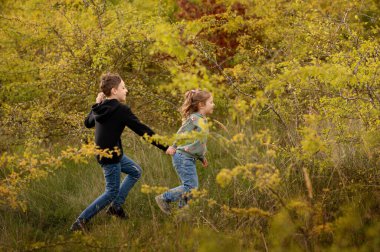 Parkta neşeyle koşan çocuklar.