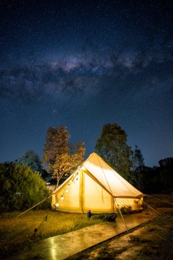 Samanyolu doğada gece aydınlığıyla parıldayan çadırın üstünde.