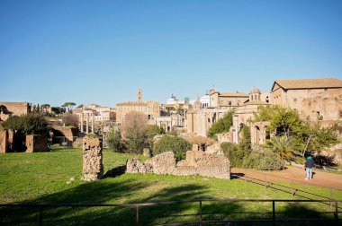 Antik Roma harabeleri ve açık mavi gökyüzünün altındaki şehir manzarası