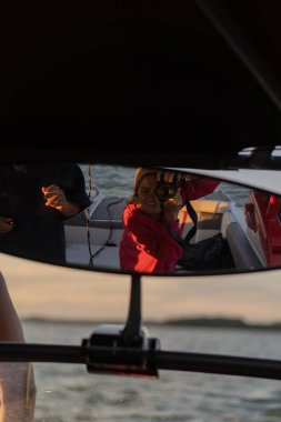 Bir kadın yatta aynada kendi fotoğrafını çekiyor.