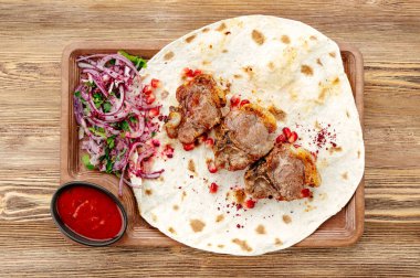 Lavaş üzerine şiş soğan, ot ve sos.