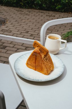 Bir fincan kahveyle bir tabak tatlı.