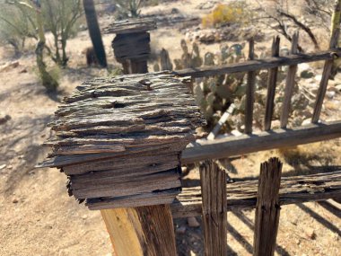 Çöl mezarlığında paslı çivilerle yıpranmış ahşap bir çit direği.