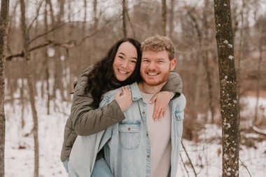 Mutlu bir çift kış ormanında karlı bir günün tadını çıkarıyor.