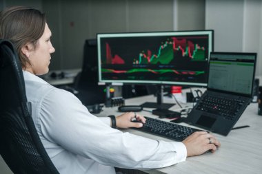 Modern bir ofiste bilgisayarının başında çalışan bir adam..