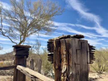 Çöl mezarlığında paslı çivilerle yıpranmış ahşap bir çit direği.
