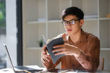 Genç adam internette çalışıyor ve araştırma yapıyor.