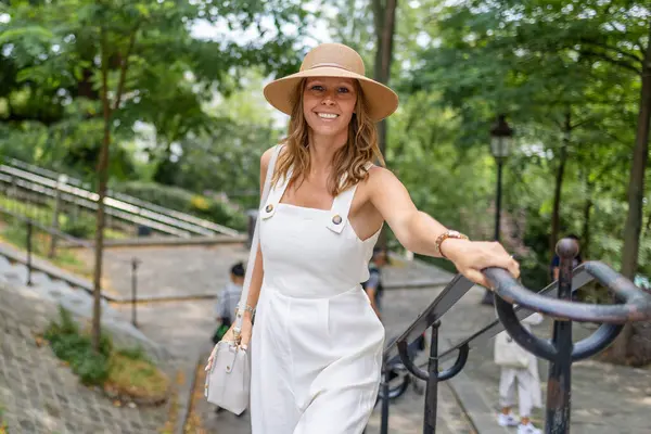 Gülümseyen kadın Montmartre 'ın manzaralı sokaklarında geziniyor.