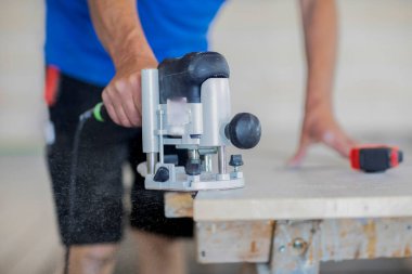 Ahşap salonda çalışan bir işçinin eli.