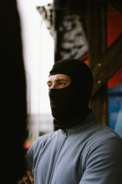 Siyah kar maskesi giyen odaklanmış bir adamın profil portresi.