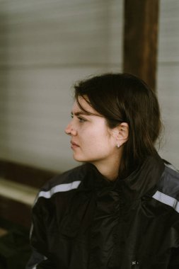 Ciddi bir kadın motorcunun portresi. Düşünceli bir ifadeyle başka yere bakıyor.