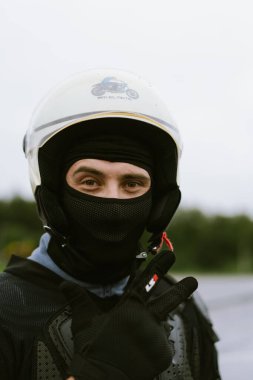 Güvenlik teçhizatı içinde motosiklet sürücüsü barış işareti gösteriyor