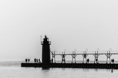 Siluetli Deniz feneri ve Yürüyen İnsanlar İskelesi