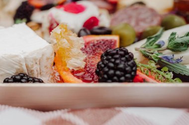 Krem peynir, bal peteği ve kan portakalı şarküteri panosuna yakın çekim..