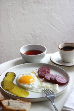Masada çırpılmış yumurta, füme sosis ve turşu..