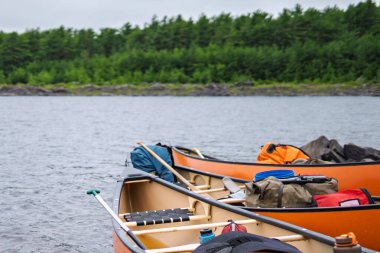 Orange canoes with gear paused for backcountry lunch
