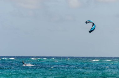 Kiteboarding adventure on turquoise waters under clear blue sky