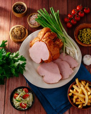 yeşil soğanlı sebzeli bir parça jambon.