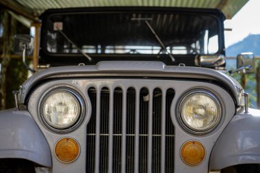 Vintage bir cip ve ızgara detaylarının önü.