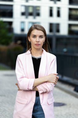 Parlak ceketli güzel kadın kameraya bakıyor.