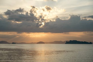 Tropical sunset seascape with islands and golden sky, Thailand