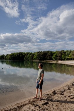 Kumsalda sakin bir gölün kenarında hayal kuran bir insan..