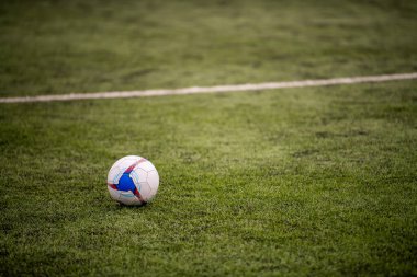 Yeşil çimlerin üzerinde futbol topu. Spor ve rekabet konsepti.