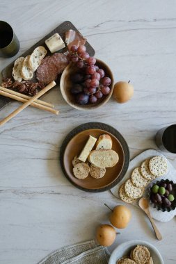 Charcuterie with grapes, cheese, nuts, crackers, and pears on a table