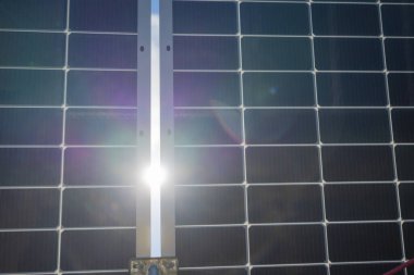 Sun bursting through solar panels in central Texas