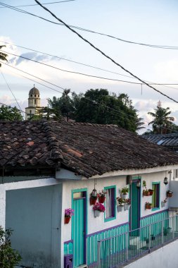 Renkli pencereleri ve kilise kulesi olan geleneksel bir ev manzarası