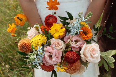 Geleneksel olmayan bir düğün buketi tutan gelin.