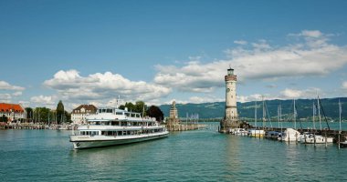 Lindau Limanı 'ndan göl kenarındaki deniz feneriyle kalkan feribot.