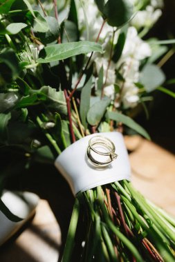 Çiçek buketinde bir çift alyans.