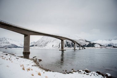 Karlı Nehir ve Dağların Üzerindeki Eğri Köprü