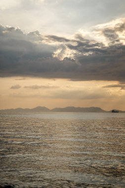 Sunset over calm sea with mountain silhouette