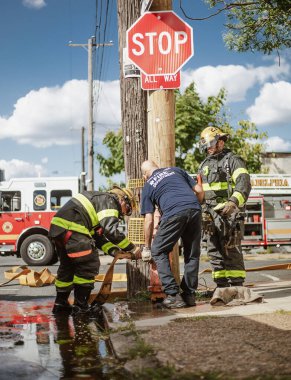 İtfaiyeciler Philadelphia 'da bir yangın musluğunu suyla dolduruyorlar.