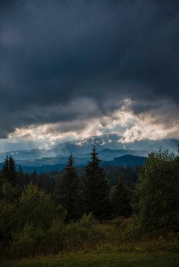 Dramatic Clouds Over Forested Mountains